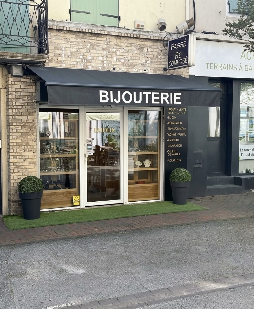 Devanture de la bijouterie Passé Recomposé à Bourgoin-Jallieu : store noir portant l'inscription Bijouterie et vitrines de bijoux